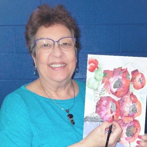 Chris Cruz holding a floral watercolor painting